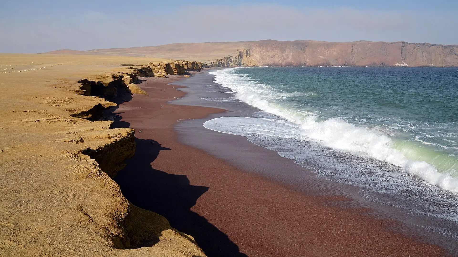 Acantilados de arena y una playa de arena rojiza en la península de Paracas