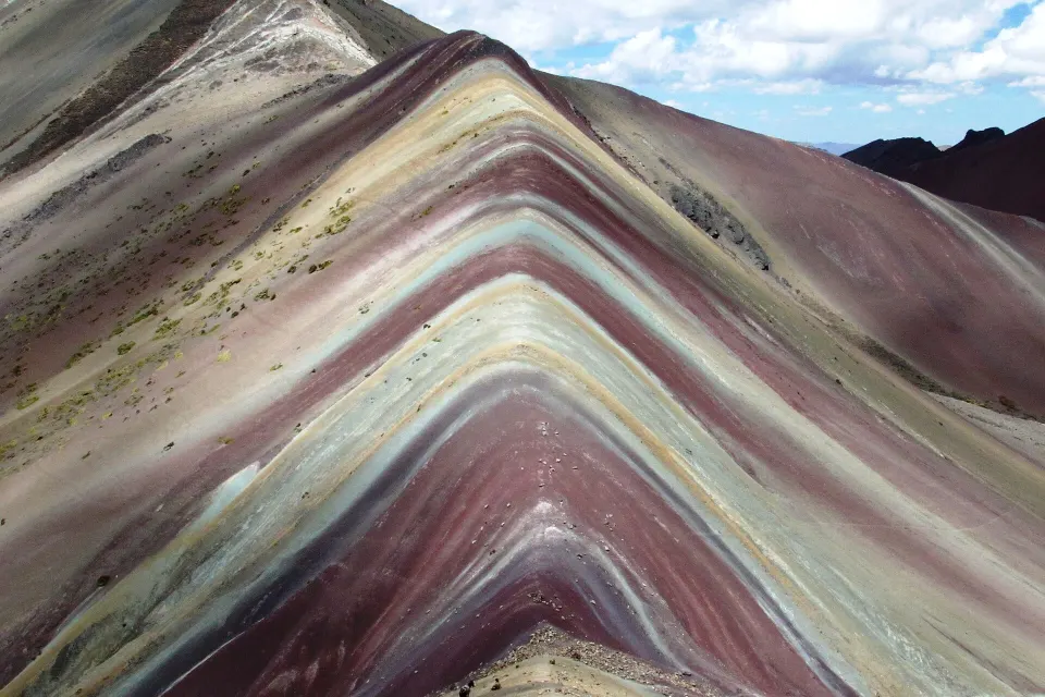 Faixas vermelhas, roxas, brancas e verdes na encosta de Vinicunca, a Montanha Colorida, na cordilheira do Vilcanota